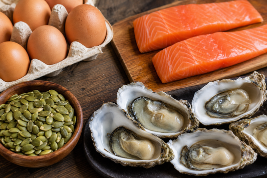 A photorealistic close‑up of natural food ingredients , eggs, oysters, pumpkin seeds, and salmon fillets arranged on a w